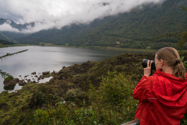 Senior Woman taking photo of scenic Lake Mahoma in Rwenzori